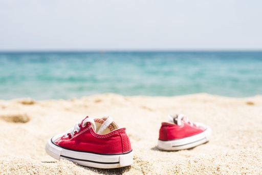 A shallow focus shot of red sneakers in the beach