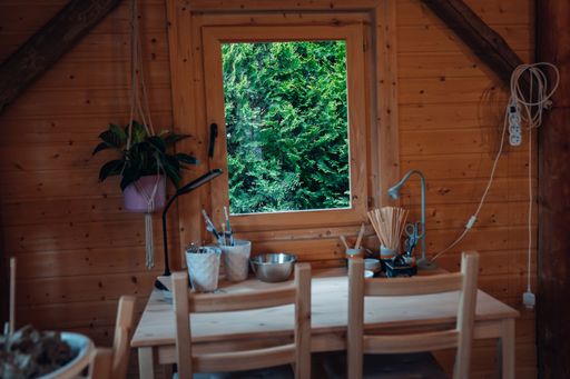 A beautiful shot of a wooden cabin with table and chairs near a window