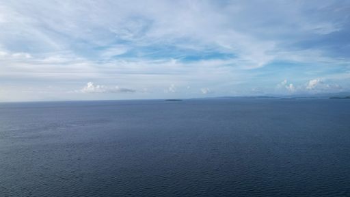 A bird's-eye view of the beautiful landscape of the sea, blue water at sunset ,near the green island. Philippines