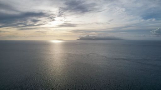 A bird's-eye view of the beautiful landscape of the sea, blue water at sunset ,near the green island. Philippines