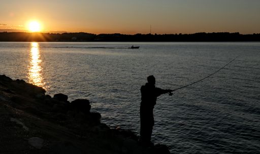A beautiful sunset view over a sea with a silhouette of a fisherman