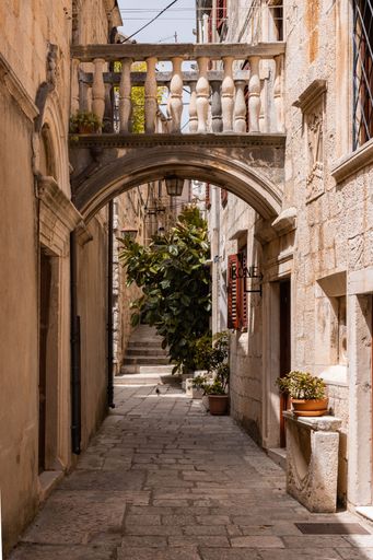 A beautiful narrow alley with bridge from one building to another in coastal Korcula town, Croatia
