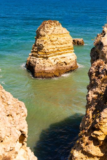 A beautiful view of huge rocks on a shore of a sea on a sunny day
