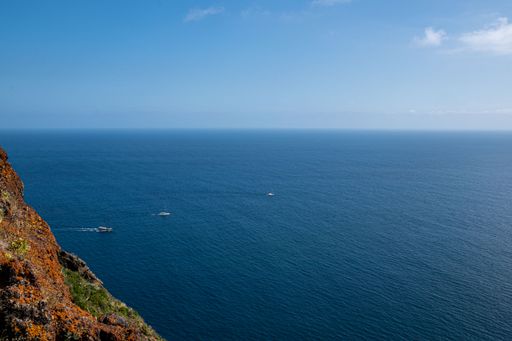 A beautiful view of a calm sea with an island under the clear sky in Madeira