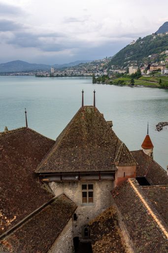 A vertical beautiful shot of an ancient Chillon Castle next to a lake Geneva in Switzerland,