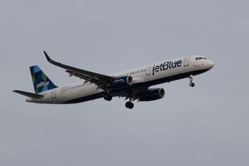 JetBlue plane against a cloudy sky preparing to land in Boston
