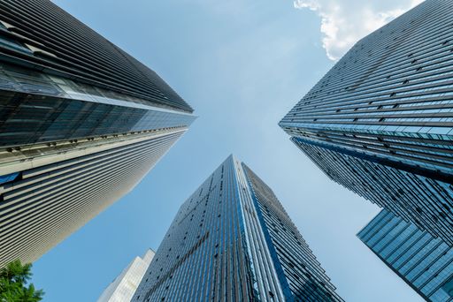 A low angle of modern office buildings and skyscrapers against the blue sky