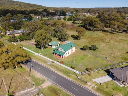An aerial view of a house near a highway on landscape background