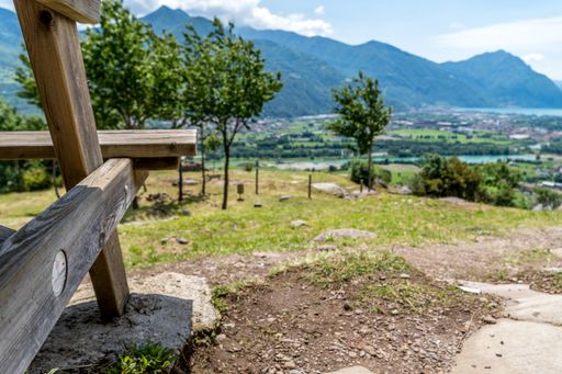 A selective focus shot of a wooden bench on the path to the giant bench in Rogno, north of Lake Iseo, located in Bergamo, Northern Italy