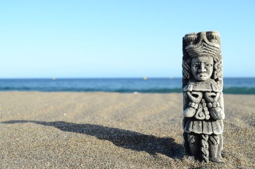 Ancient Maya Statue on the Sand Beach near the Ocean
