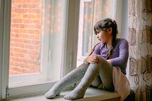 A Close-up of a woman drinking coffee looking out of a window