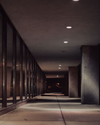 A vertical shot of an empty corridor of a building during night