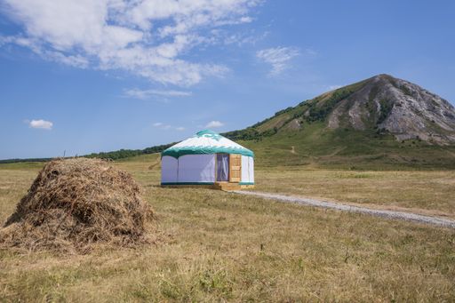 Three pyramids under the open blue sky: haystack, nomad's house (Bashkir white yurt) and mountain. Feng Shui in the open.
