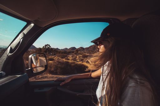 A blonde Caucasian female in front seat of a truck in Joshua Tree, California