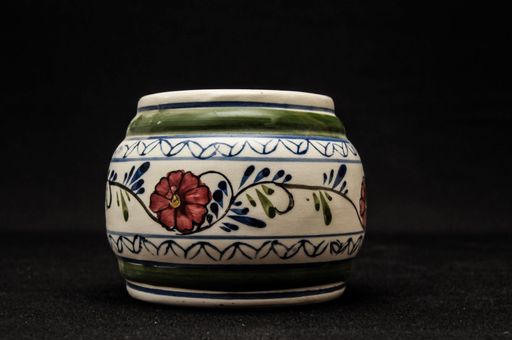 Colorful designed clay vase over a Black background