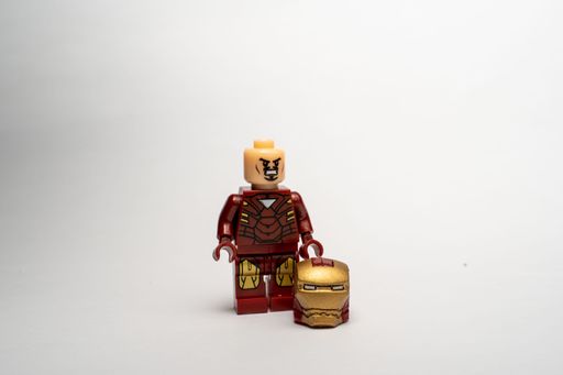 A mini lego figure of the Iron Man on a white background with his hat down