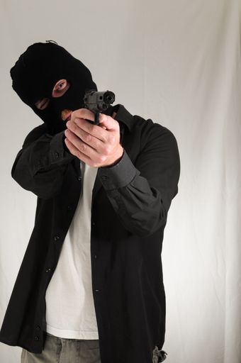 Black Dressed Young Man Holding a Pistol Gun