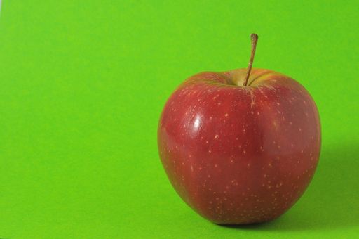 One Juicy Hot Red Apple over a Colored Background