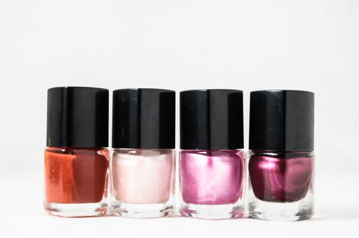 Colorful nail polish brush over white background