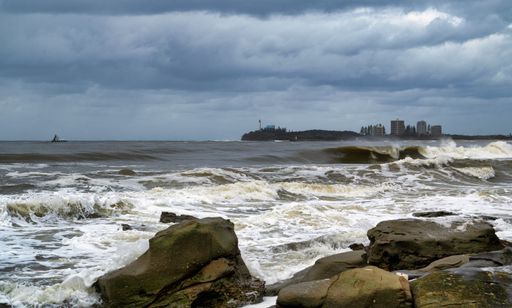 Restless sea waves washing over a rocky beach after a storm