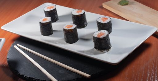 A close up shot of delicious sushi on a white plate served with soy sauce