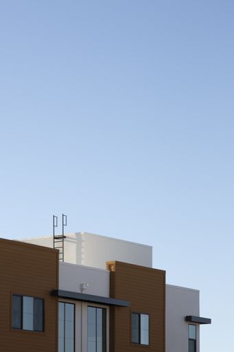 A vertical shot of a modern house with a clear blue sky in the background at daytime