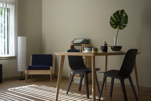 An interior shot of a living room with black chairs and a wooden table