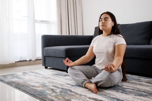 A caucasian girl doing a meditation in classic yoga pose, and self-cultivation in the house