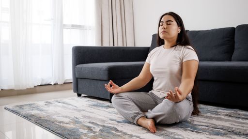 A caucasian girl doing a meditation in classic yoga pose, and self-cultivation in the house