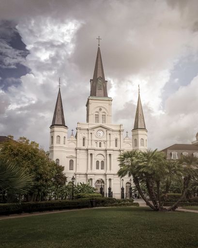 A vertical shot of the Saint Louis Cathedral in Jackson Square under a mystic cloudy sky