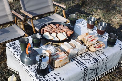 A closeup shot of a breakfast table with sandwiches and sausages