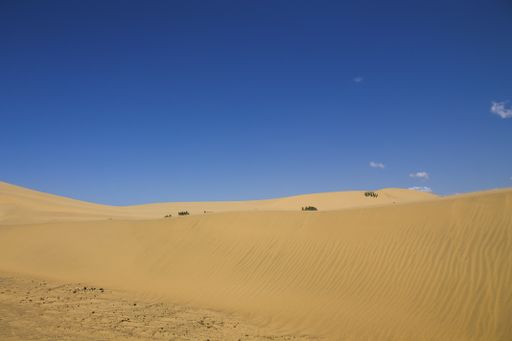 The brown sand in the desert under the blue sky