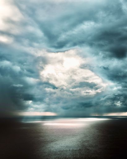 A vertical shot of a sea under a gloomy dramatic sky