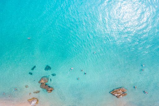 An aerial top-view of a beautiful crystal sea coast on a sunny day in Greece