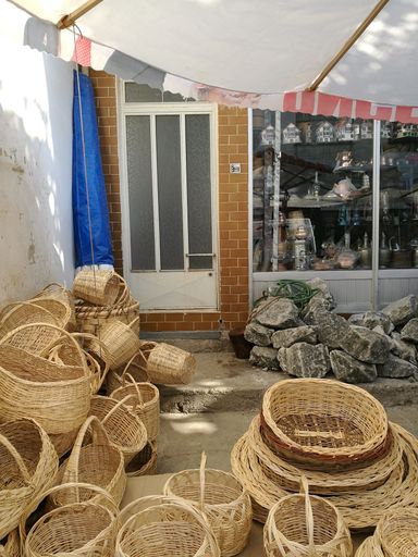 A vertical shot of picnic baskets of various shapes and sizes in front of a house