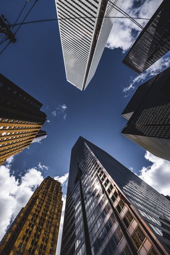 A vertical low angle shot of modern skyscrapers on blue cloudy sky background in Toronto, Canada