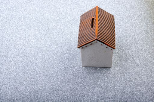 A high angle view of a small house-shaped money box on the table