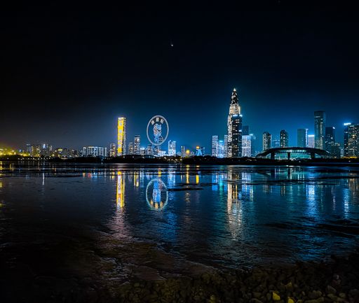 A breathtaking night view of the Victoria Harbor and the Shenzhen city skyline in Hong Kong reflected in the water