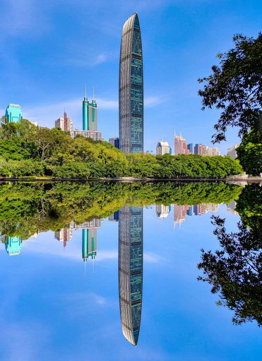 A vertical shot of skyscrapers and trees reflected in the water in Shenzhen, Hong Kong