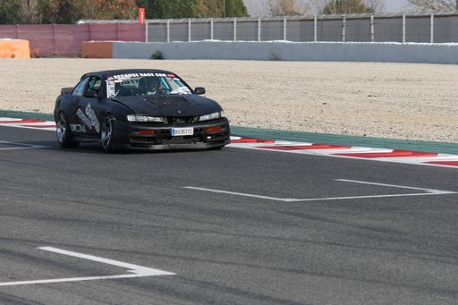 A drifting black tuning car on the race track 
model Nissan Silvia S14