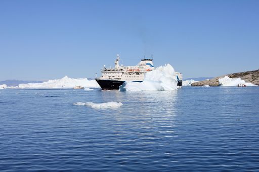 22 July 2011, Ilulissat, Greenland, Huge cruise ship anchoring between icebergs (horizontal)