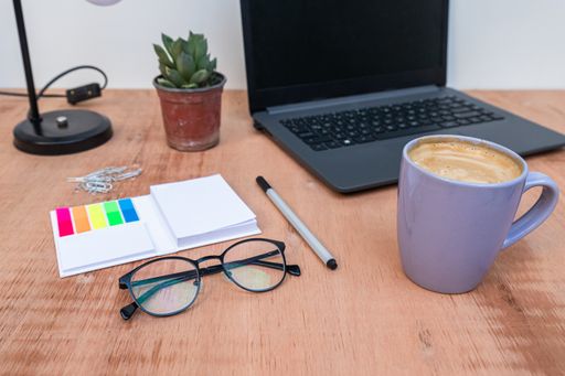 The office supplies on a desk with a cup of coffee to work from home because of Covid-19 pandemic