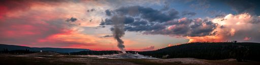 A panoramic view of Old Faithful Geyser at colorful sunset in Yellowstone National Park, Wyoming