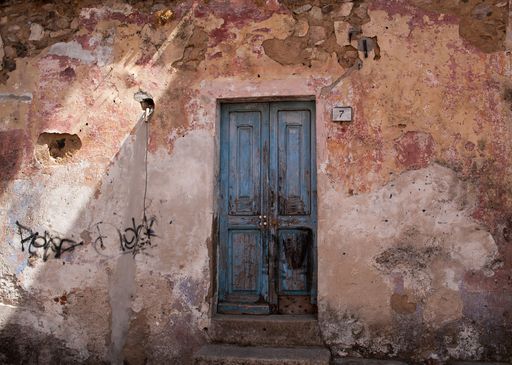 An exterior view of an old building with a wooden door in Mallorca, Spain