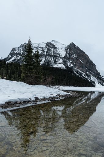 A beautiful shot of rocky mountains reflected in the lake in Banff National park in winter