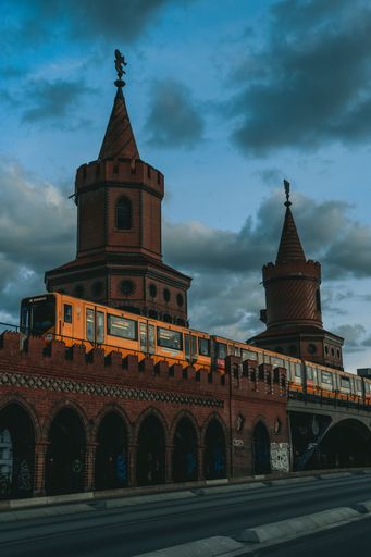 A picture of a metro train on a bridge in front of an old building in Berlin, Germany