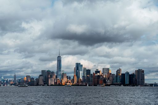 A cityscape of bustling New York city during daytime with a cloudy sky