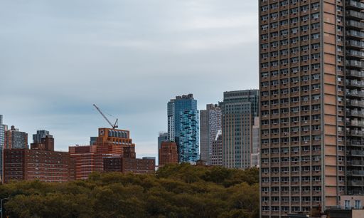 A cityscape of bustling New York city during daytime with a cloudy sky
