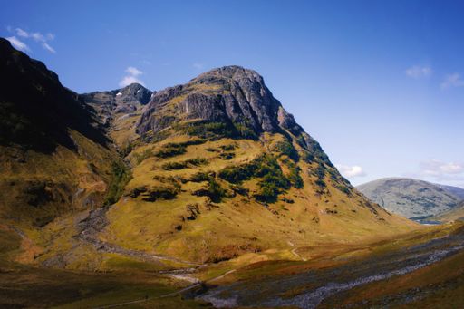 A closeup shot of Three Sisters in Glencoe Scottish Highlands during sunset with blue sky above