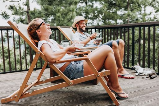 A couple enjoying coffee on a balcony in the mountains